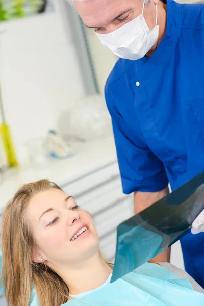 Dentista mostrando rayos X a paciente femenino — Foto de Stock