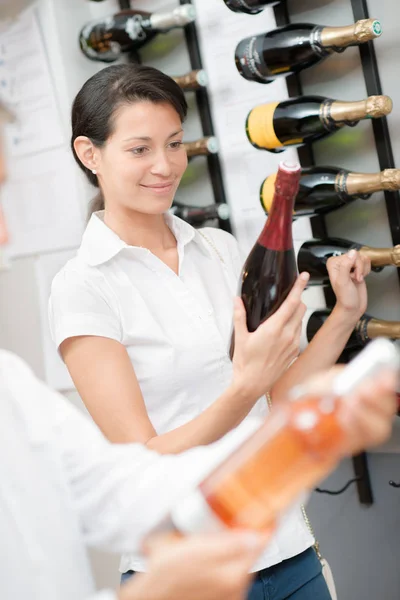 Женщина покупает бутылку хорошего вина — стоковое фото