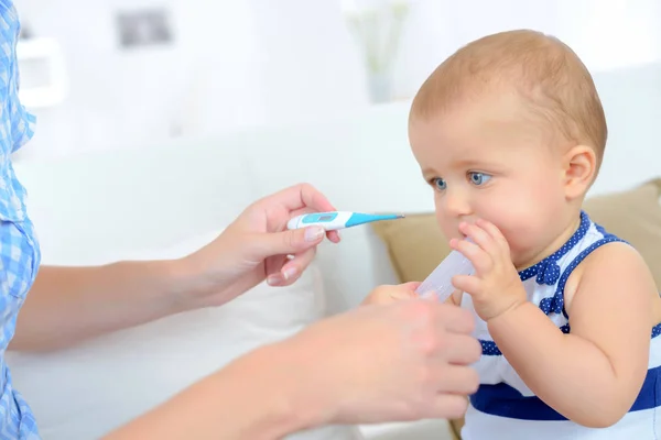 Mulher tomando babys temperatura — Fotografia de Stock