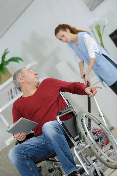 Женщина-помощник со взрослым мужчиной-инвалидом — стоковое фото