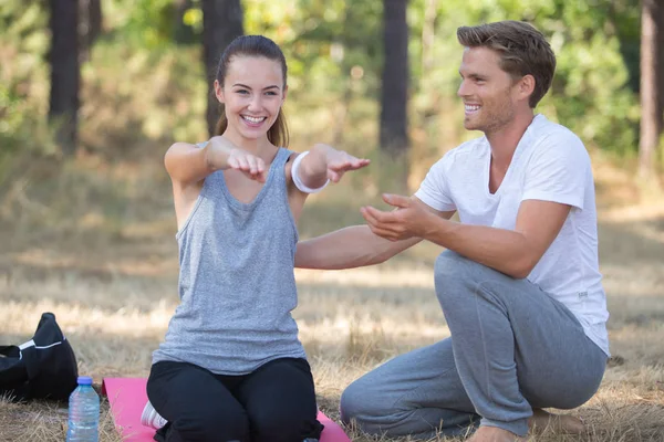 Young couple training yoga in the park — Stock Photo, Image