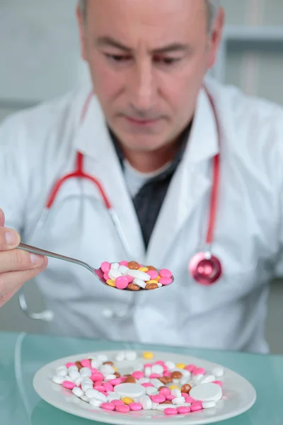 Doktor bir plaka üzerinde renkli hapları ile — Stok fotoğraf