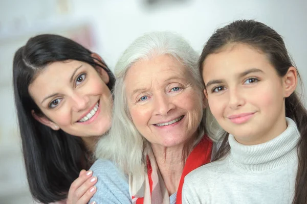 Família feliz de três gerações sorrindo e olhando para a câmera — Fotografia de Stock