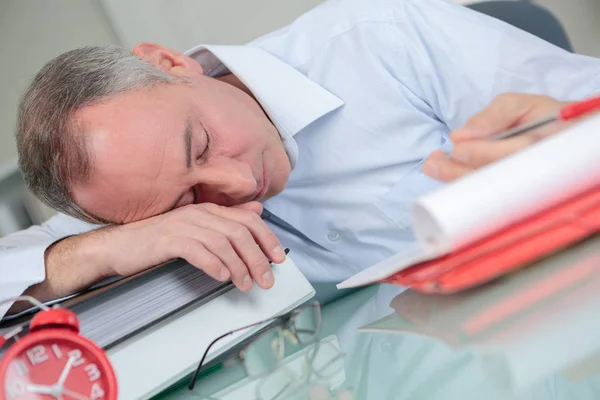 Estresado hombre sobrecargado de trabajo estudiando somnoliento en escritorio — Foto de Stock