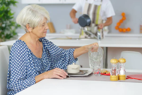 Stara kobieta w domu jedzą śniadanie — Zdjęcie stockowe