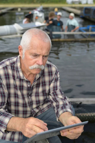 Pescador empresario sosteniendo una tableta — Foto de Stock
