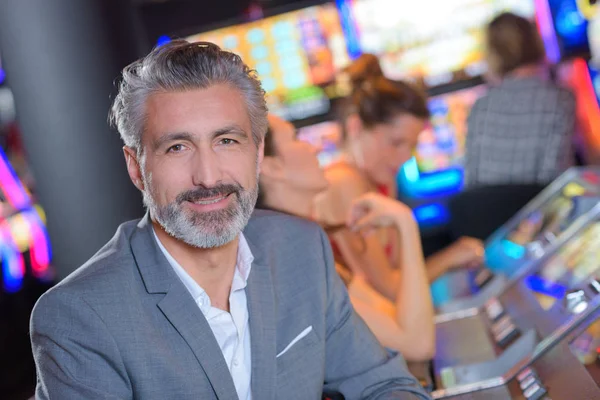 Bel homme avec machine à sous dans le casino — Photo