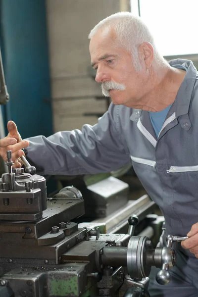 Starszy pracownik metalu za pomocą maszyny w warsztacie — Zdjęcie stockowe