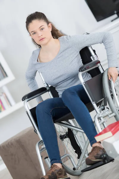 Молодая женщина в инвалидном кресле смотрит в камеру — стоковое фото
