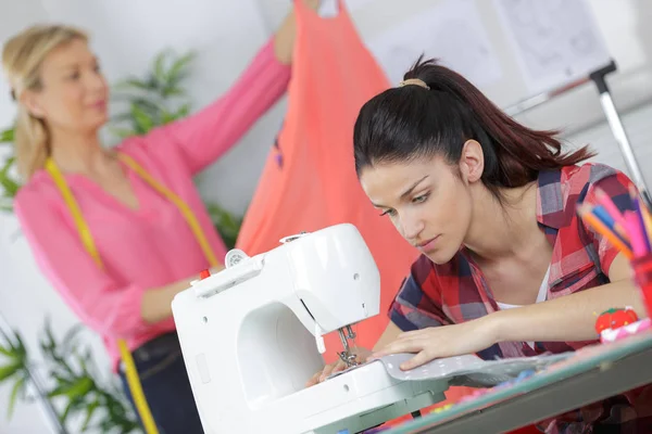 Jovem mulher trabalhando com uma máquina de costura — Fotografia de Stock
