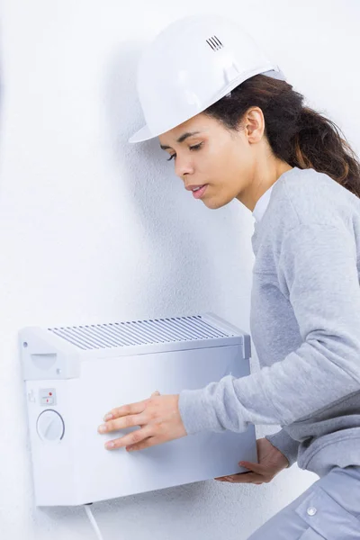 Femme montage radiateur au mur — Photo