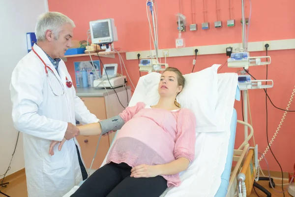 Mujer embarazada siendo monitoreada por el médico —  Fotos de Stock