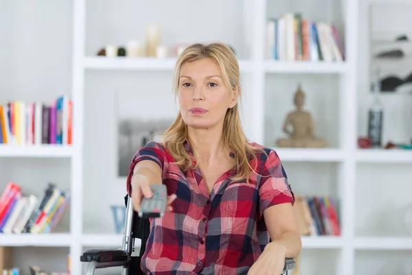 Behinderte Frau schaut zu Hause im Wohnzimmer fern — Stockfoto