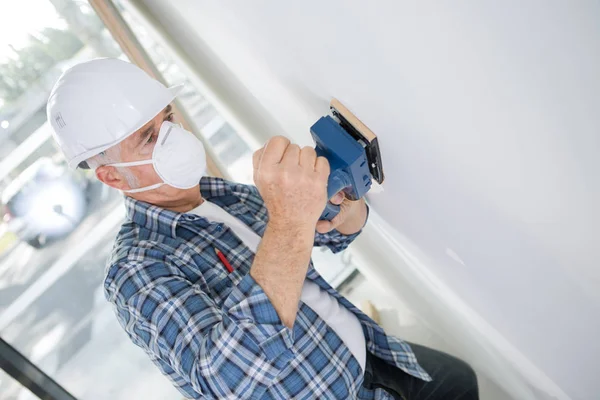 Vieux constructeur en dur mur de ponçage à l'intérieur — Photo