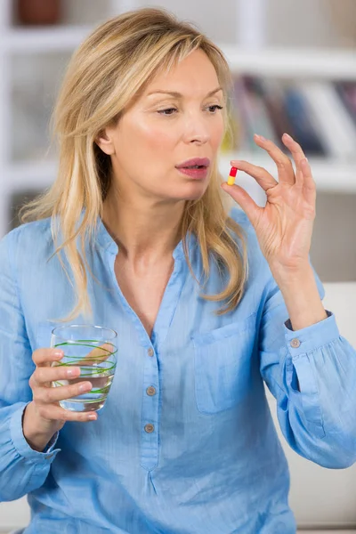Felnőtt nő, aki otthon szed tablettákat. — Stock Fotó