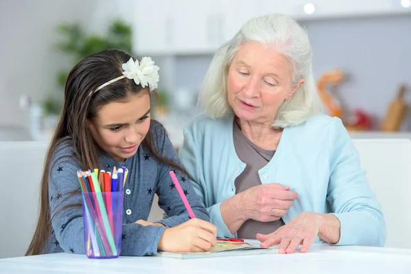 Petit-enfant dessin à la maison avec grand-mère — Photo