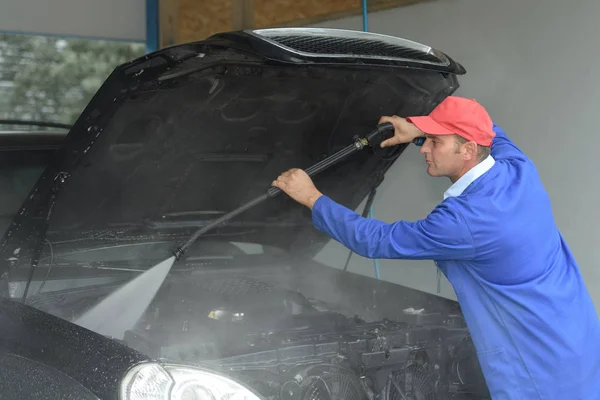 Зображення працівника, що очищає двигун автомобілів з каршером — стокове фото
