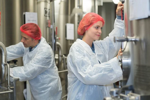 Man and woman working on vats — Stock Photo, Image