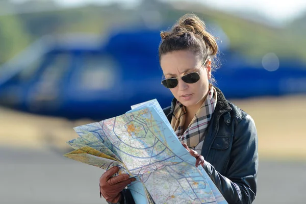 Vrouw leest een kaart in het asfalt — Stockfoto