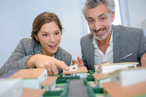 Hombre y mujer mirando con entusiasmo el modelo de vivienda — Foto de Stock