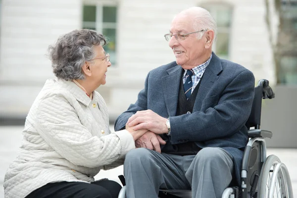 Casal em cadeira de rodas conversando juntos visitando a cidade — Fotografia de Stock