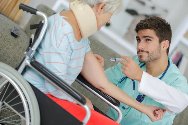 Krankenpfleger spritzt behinderter Seniorin zu Hause Spritzen — Stockfoto