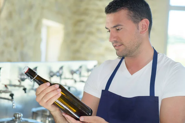 Ritratto di un birraio felice con in mano una bottiglia di birra — Foto Stock