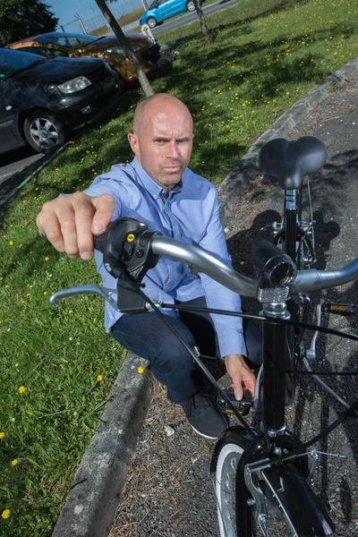 Człowiek mocowania koła rowerowego w parku — Zdjęcie stockowe