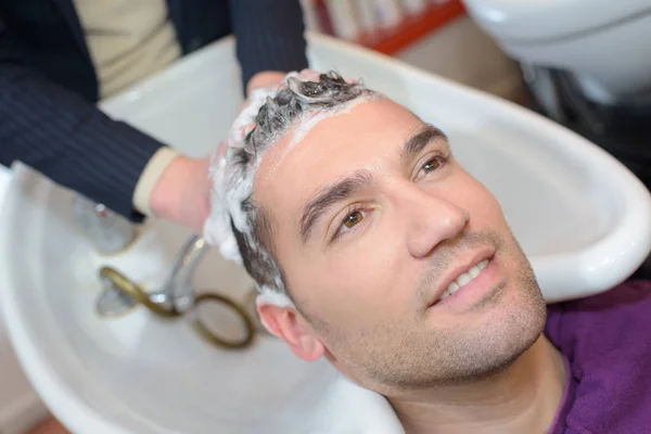 Mladý muž si hairwash v salonu krásy — Stock fotografie
