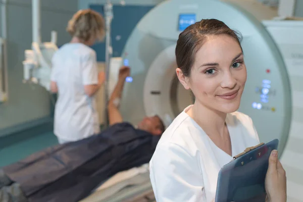 Radióloga sonriente con colegas de pie junto a mri machi —  Fotos de Stock