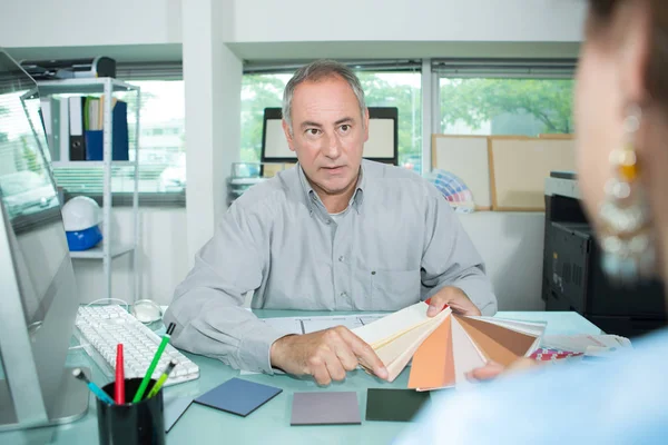 Homme regardant des échantillons de couleur dans le bureau du concepteur — Photo