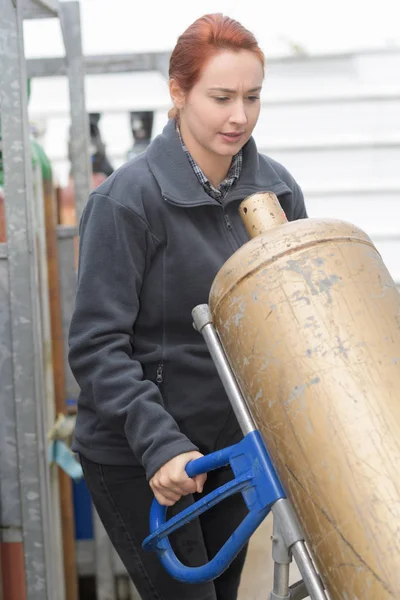 Vrouwelijke u bedrijf een gasfles — Stockfoto