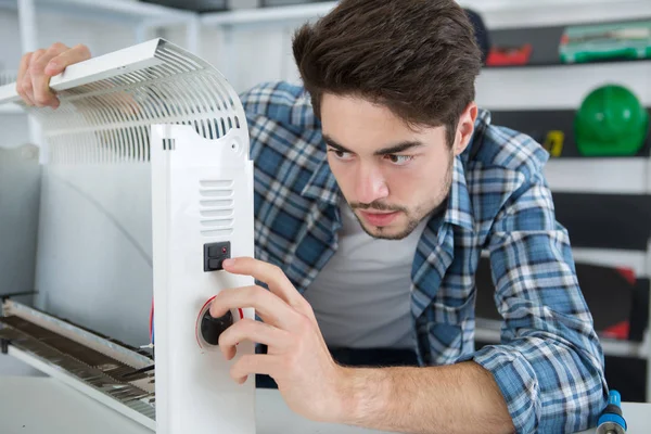 Young repairer fixing radiator at home — Stock Photo, Image