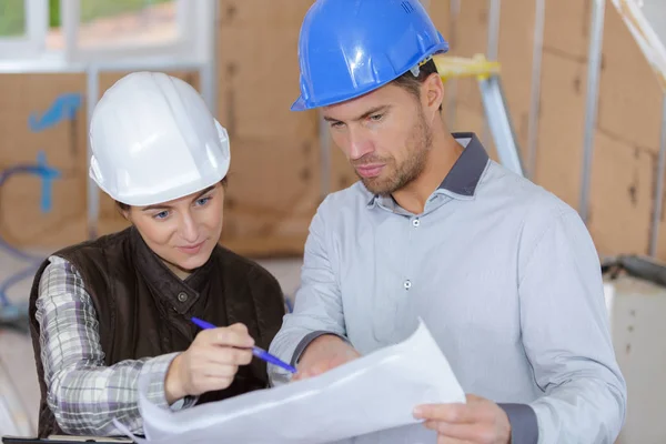 Fröhliche Kollegen begutachten gemeinsam Dokumente vor Ort — Stockfoto