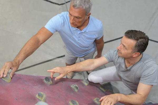 Uomo anziano guardando la struttura di arrampicata al coperto — Foto Stock