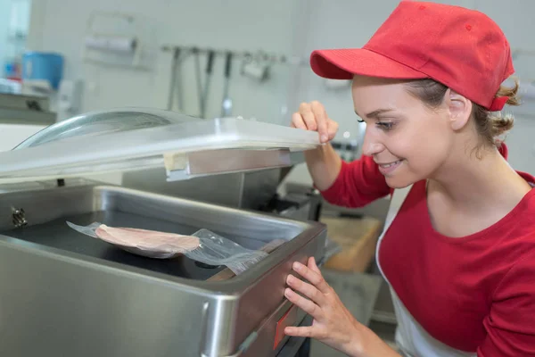 Açougueiro fêmea vácuo embalagem alguma carne — Fotografia de Stock