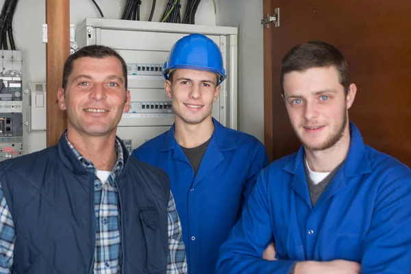 Young electricians in front of fuse switch board — Stock Photo, Image