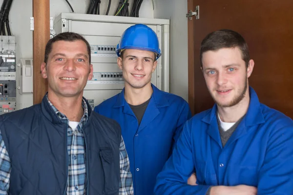 Electricistas jóvenes delante del tablero de fusibles —  Fotos de Stock