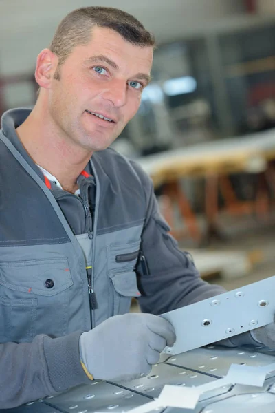 Workman holding metal components — Stock Photo, Image