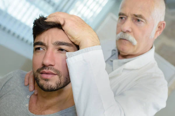 Homem recebendo massagem na cabeça em consultório médico — Fotografia de Stock