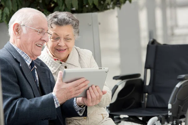 오래 된 커플 그들의 손아귀에서 태블릿 pc와 카메라를 찾고 — 스톡 사진