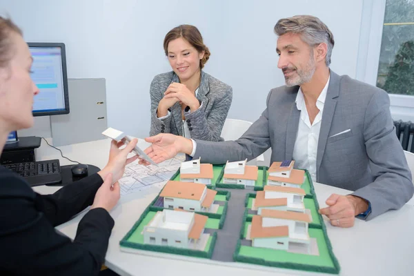 Pareja con agente de bienes raíces discutiendo proyecto — Foto de Stock