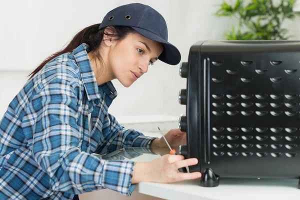 Meisje vaststelling van toestel en elektricien — Stockfoto