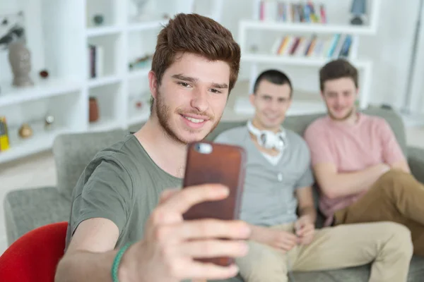 Amigos tomando selfies en un smartphone en una casa encantadora —  Fotos de Stock