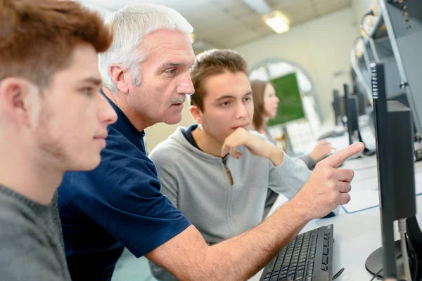 Timmerman opleiding mannelijke leerling om gemechaniseerde zaag te gebruiken — Stockfoto