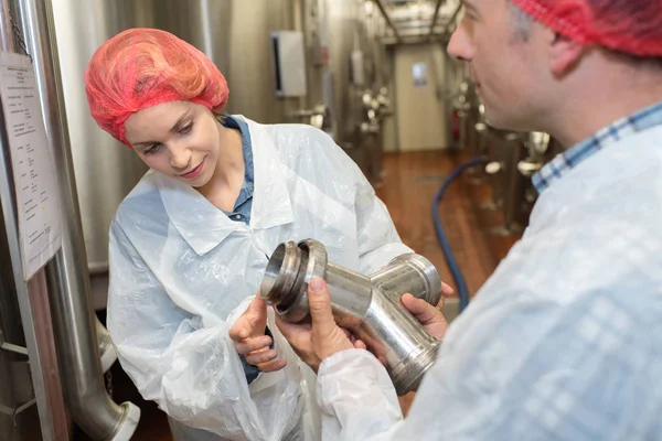 2 factory employees holding pipe — Stock Photo, Image