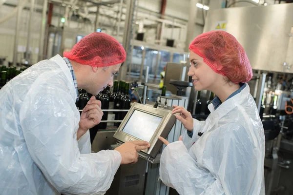 Trabalhadores olhando para a tela de controle da máquina — Fotografia de Stock