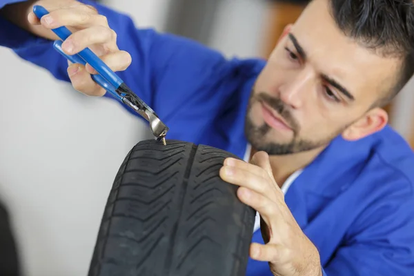 Mecánico automático sacar clavo de neumático con garra — Foto de Stock