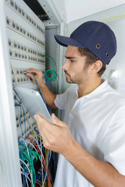 Konzentrierter Elektriker, der Sicherheitsverfahren anwendet, während er an der Schalttafel arbeitet — Stockfoto