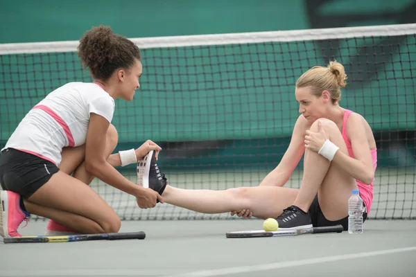 Due tennisti che allungano la gamba all'aperto — Foto Stock